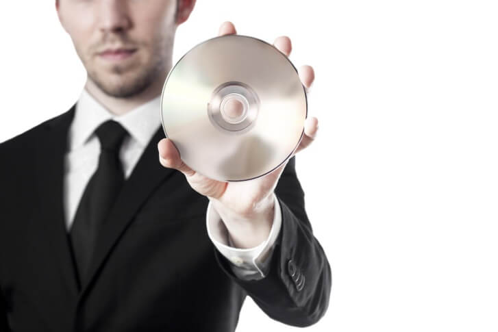 man in suit holding DVD